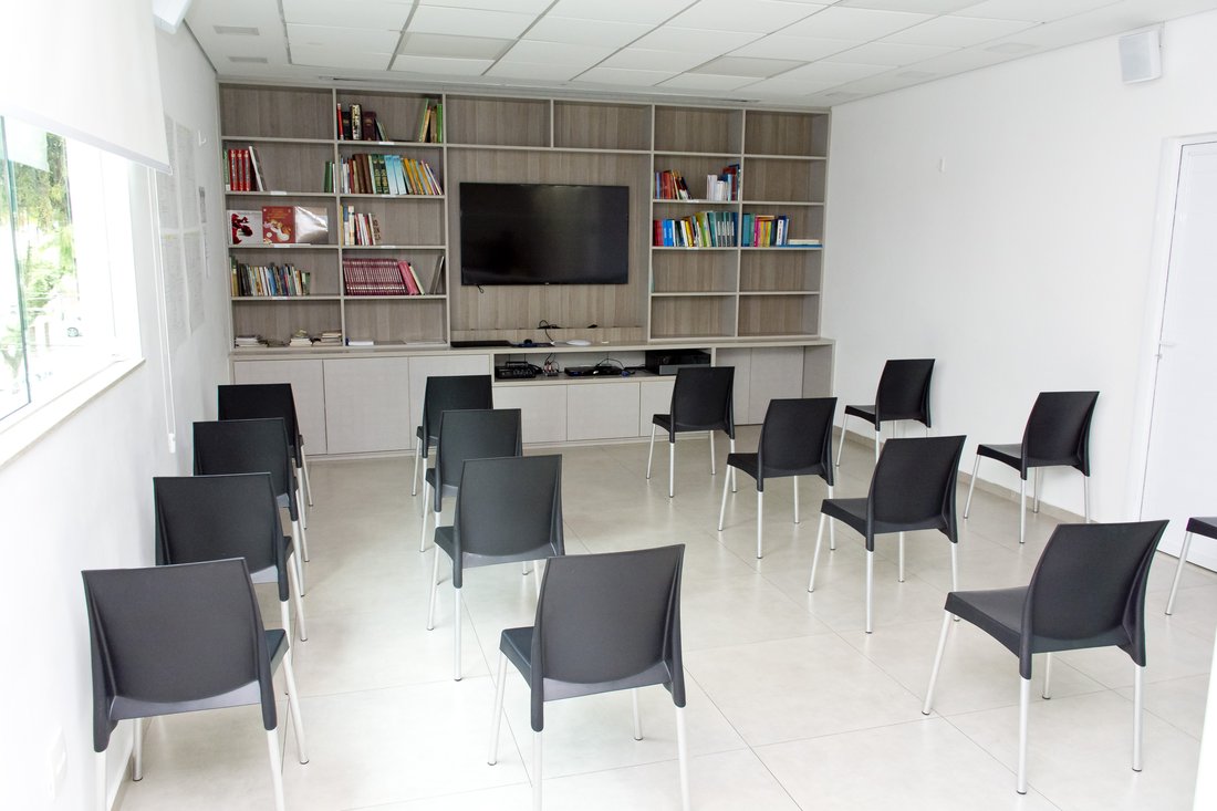 Sala de acolhimento da Mar Saúde, com cadeiras e estante